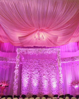 Reception decor with white flowers and pink lights by The Wingmen